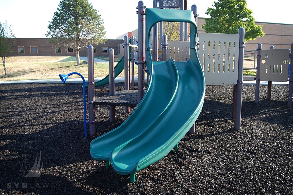 image of mission trail elementary playground with a tan double slide on top of rubber mulch