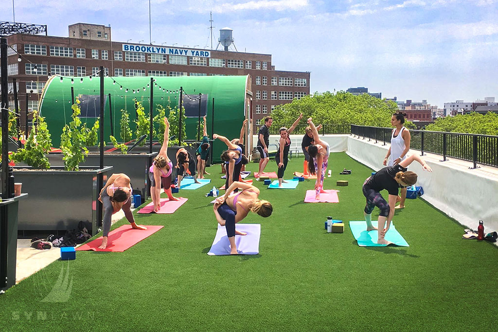 image of a rooftop yoga class on artificial grass
