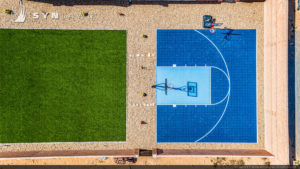 Aerial view over a half basketball quart and artificial grass surfacing