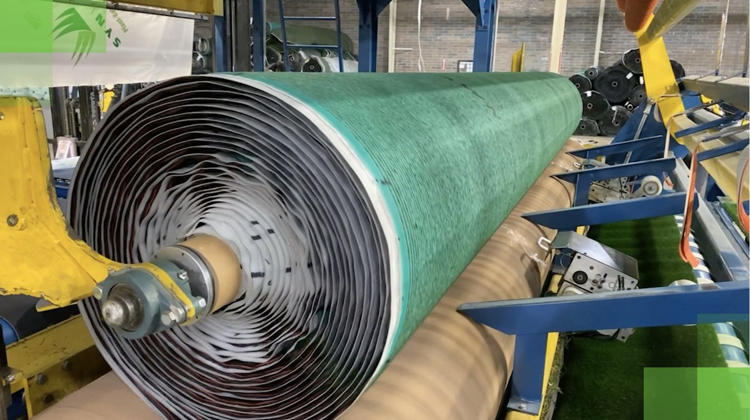 SYNLawn_ManufacturingImage_Homepage large roll of artificial turf in the manufacturing warehouse
